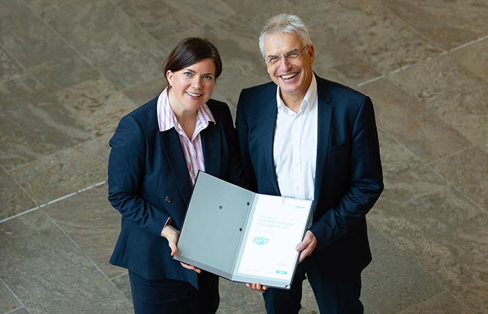 Caroline Pim, Vice President Power Systems DACH bei Schneider Electric und Uwe König Geschäftsführer von con terra bei der Unterzeichnung des Partnerschaftsvertrages